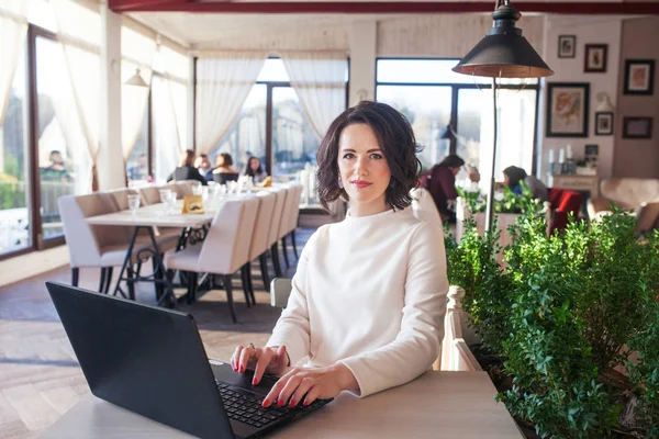 Adulte élégante femme d'affaires en robe blanche assis avec ordinateur portable i — Photo