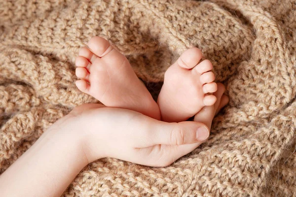 Baby feet in brother hands. Tiny Newborn Baby's feet  closeup. — Stock Photo, Image