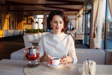 Hoş bir kafede çay içen güzel kadınlar. İş kadınları çay fincanına ara verir. Şık bir kafede parlak bir yaşam tarzı fotoğrafı.