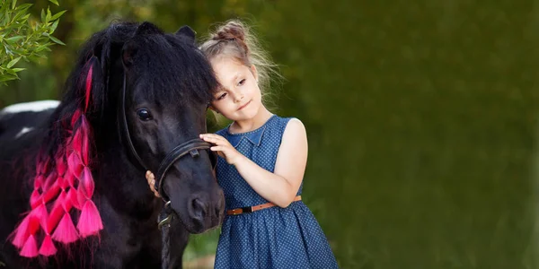 Милая Маленькая Девочка Черный Пони Красивом Парке Красивая Девушка Обнимает — стоковое фото