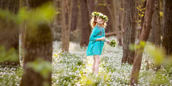 美丽的小女孩穿着蓝色的衣服在春天的树林里散步 一个头戴花环的漂亮姑娘的画像 可爱的园丁种植雪滴 复活节到了复制文本的空间 — 图库照片