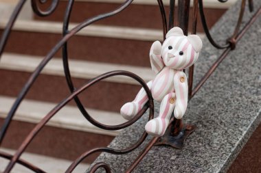 Oyuncak ayının fotoğrafı. Keten kumaştan yapılmış klasik bir oyuncak ayı. Sahte kafesin üzerinde oturan yalnız bir oyuncak ayı.