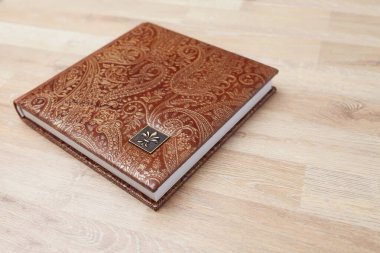 Fotoğraf kitabı, defter ya da gerçek deri kapaklı günlük. Kahverengi ve dekoratif damgalı. Düğün ya da aile fotoğrafı albümü. Aile değeri.