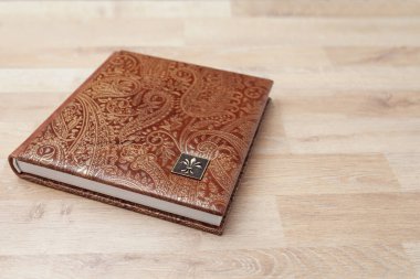 Fotoğraf kitabı, defter ya da gerçek deri kapaklı günlük. Kahverengi ve dekoratif damgalı. Düğün ya da aile fotoğrafı albümü. Aile değeri.