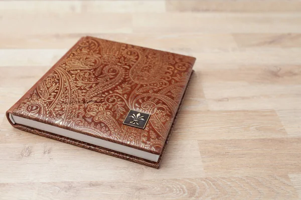 Photo book, notebook or diary with a cover of genuine leather. Brown color with decorative stamping. Wedding or family photo album. Family value.