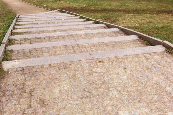 Steps of paving stones leading down. Path in the Park