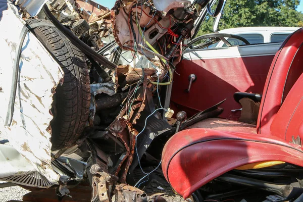 The detail of an old veteran small car after the collision with a modern car during the traffic accident. The car is destroyed completely. Shows the low level of passive safety.