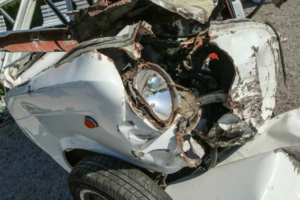 The detail of an old veteran small car after the collision with a modern car during the traffic accident. The car is destroyed completely. Shows the low level of passive safety.