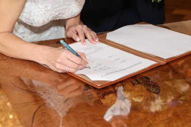 Düğün töreninin ayrıntıları. Gelin, törenden sonra yeni ismiyle belgeyi imzalıyor..