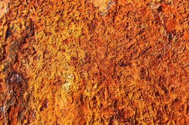 Sarının, kahverenginin ve turuncunun farklı tonlarında paslanmış metal bir plakanın ayrıntıları..