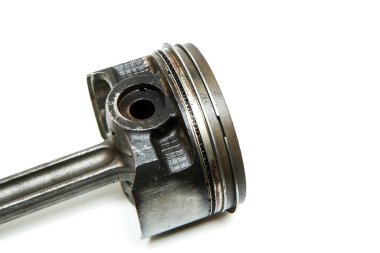 Spor motorunun bağlantı çubuğuyla birlikte kullanılan ve kirli piston beyaz arka planda izole edilmiş..