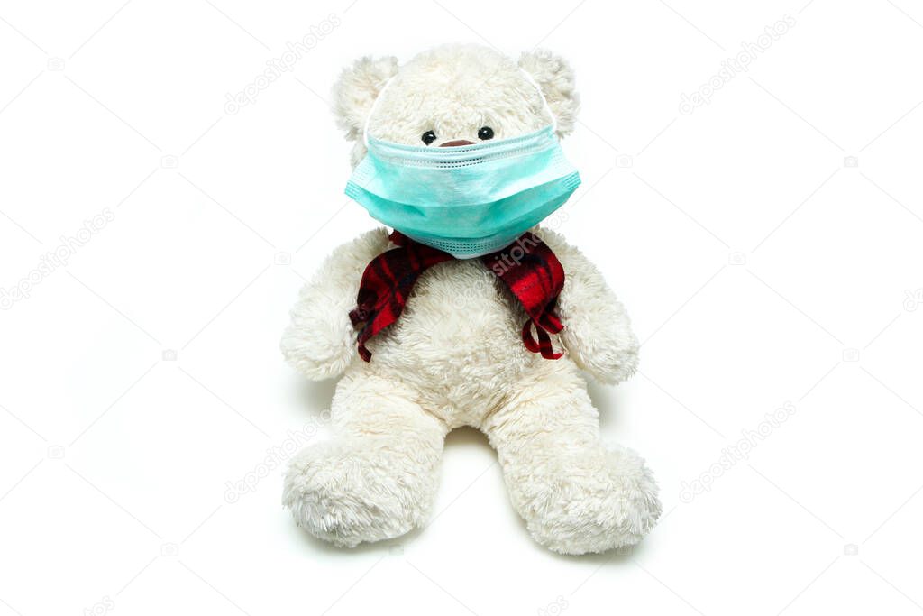 The plush teddy with a mask on his face. as a symbol of protection against viruses like corona virus. Everybody has to wear a mask.