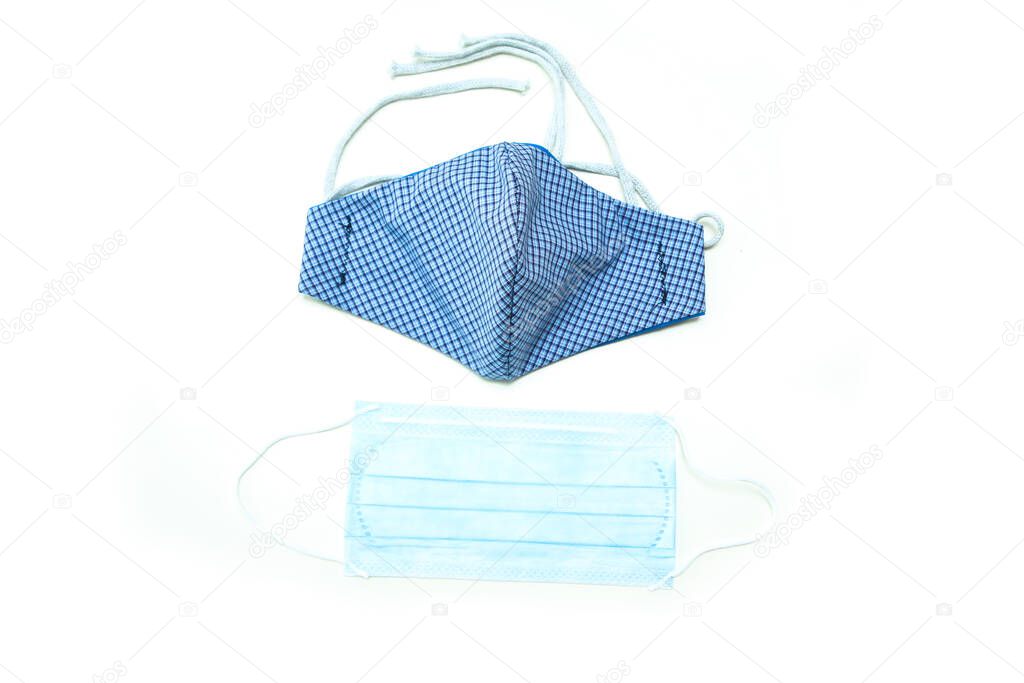 The home made textile mask as a protection against transfer of the viruses like coronavirus. Made because of lack of aids. Comparison with paper one-time mask. Isolated on white background. 
