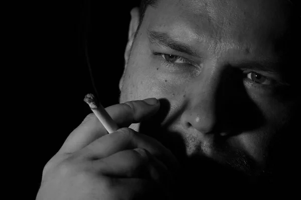 Hombre joven fumando cigarrillo monoschome — Foto de Stock