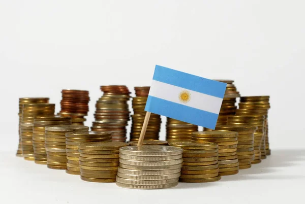 Αργεντινή σημαία κυματίζει με στοίβα των χρημάτων νομισμάτων — Φωτογραφία Αρχείου