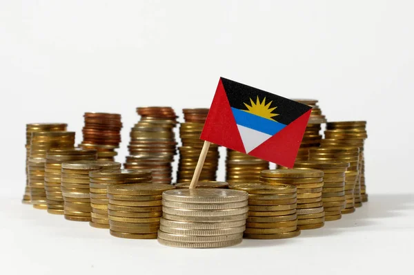 Antigua y Barbuda bandera ondeando con pila de monedas de dinero —  Fotos de Stock