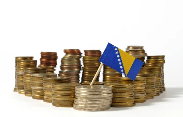 Bósnia e Herzegovina bandeira acenando com pilha de moedas de dinheiro — Fotografia de Stock