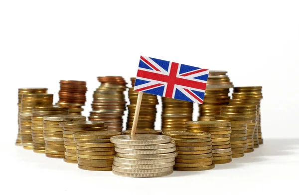 ग्रेट ब्रिटेन ध्वज मुद्रा सिक्कों के ढेर के साथ लहर रहा है — स्टॉक फ़ोटो, इमेज