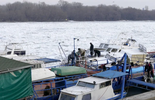 Белград, Сербия. 16 января 2017: Люди вывозят затонувшую лодку из замерзшей реки Дунай в Белграде, Сербия — стоковое фото