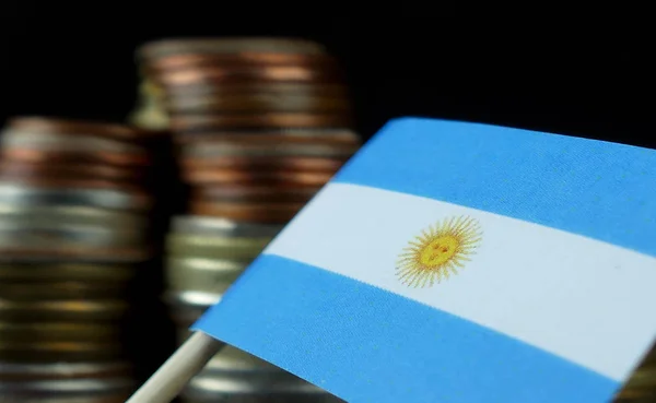 Argentinská vlajka mávala s hromadou peněz mincí makro — Stock fotografie