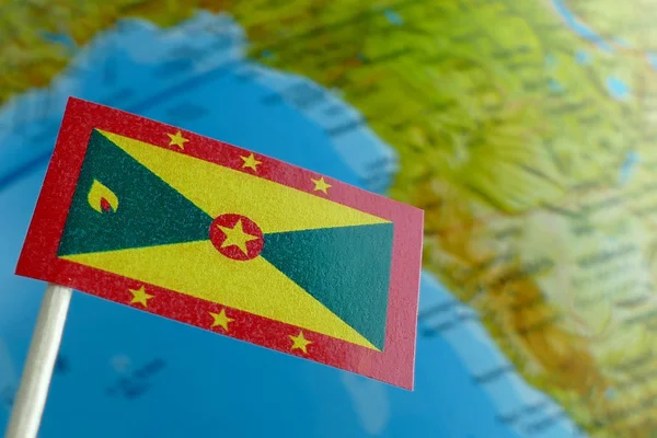 Grenada flag with a globe map as a background macro — Stock Photo, Image