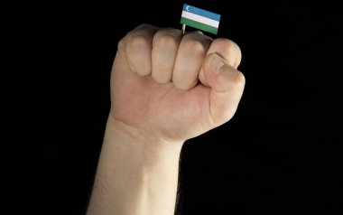 Adam el yumruk ile siyah arka plan üzerine izole Özbekistan bayrağı