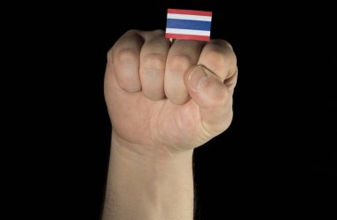 Adam el yumruk ile Tayland bayrağı siyah arka plan üzerine izole