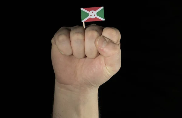 Кулак рука людини з Бурунді прапор ізольовані на чорному фоні — стокове фото