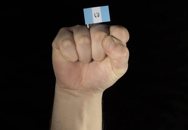 Рука человека с гватемальским флагом на черном фоне — стоковое фото