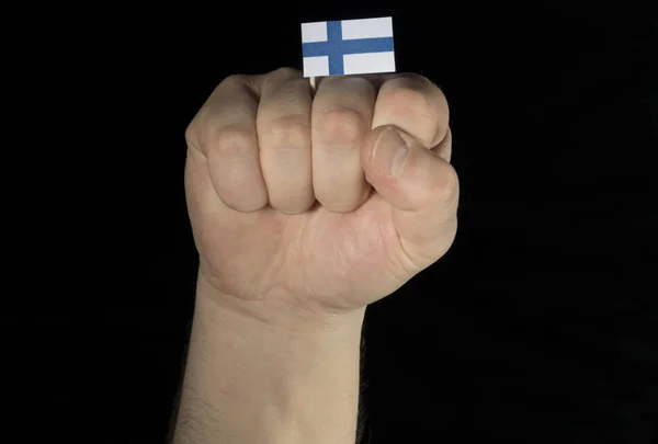 黒の背景に分離されたフィンランドの国旗と男の手拳 — ストック写真