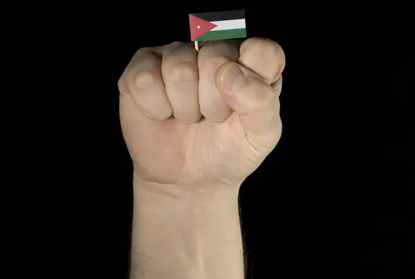 Man hand fist with Jordanian flag isolated on black background — Stock Photo, Image
