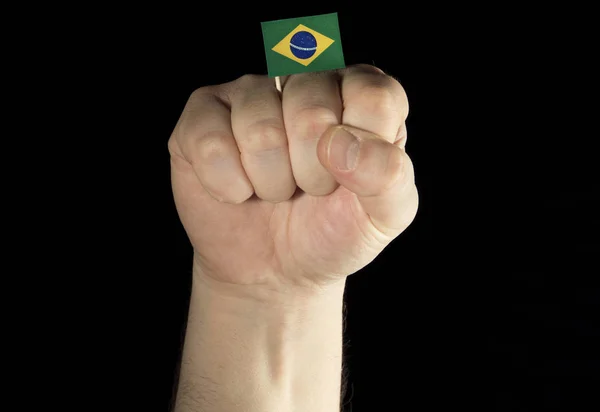 Man hand vuist met Braziliaanse vlag geïsoleerd op zwarte achtergrond — Stockfoto