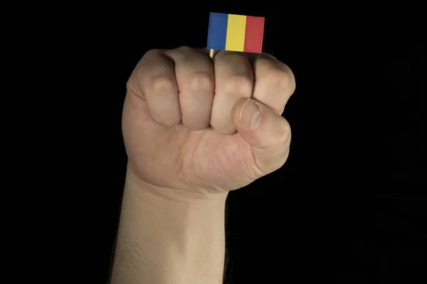 Ο άνθρωπος χέρι γροθιά με Τσαντ σημαία που απομονώνονται σε μαύρο φόντο — Φωτογραφία Αρχείου