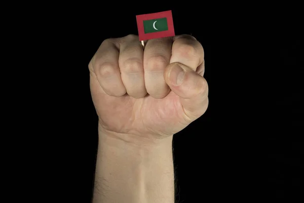 Mann Faust mit maledivischer Flagge isoliert auf schwarzem Hintergrund — Stockfoto