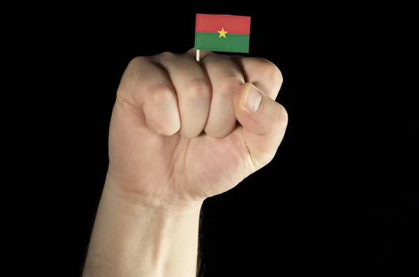 Muž ruka pěst s Burkina Faso vlajky izolované na černé poza — Stock fotografie