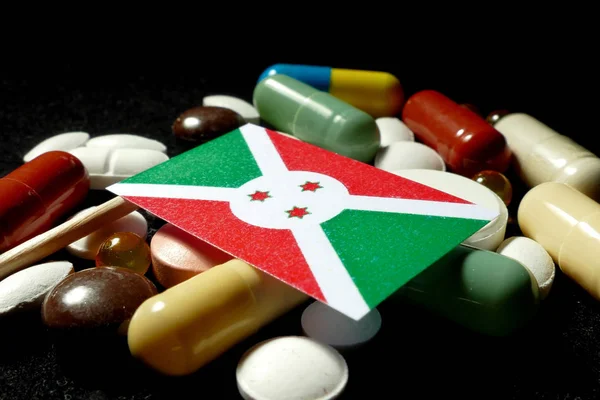 与大量医疗丸上黑色孤立布隆迪国旗 — 图库照片