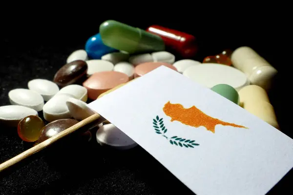Bandeira cipriota com muitos comprimidos médicos isolados em preto — Fotografia de Stock