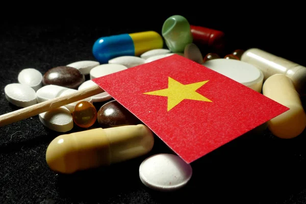 越南国旗与大量医疗丸上黑色孤立 — 图库照片