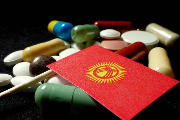 吉尔吉斯斯坦国旗与大量医疗丸上黑色孤立 — 图库照片