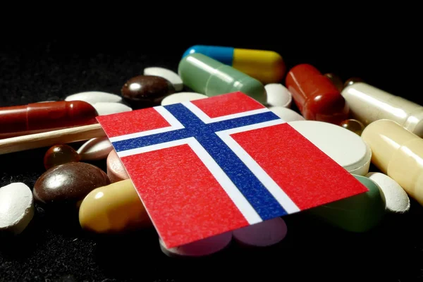 Norweski flaga z dużo medycznych pigułki na czarnym tle — Zdjęcie stockowe