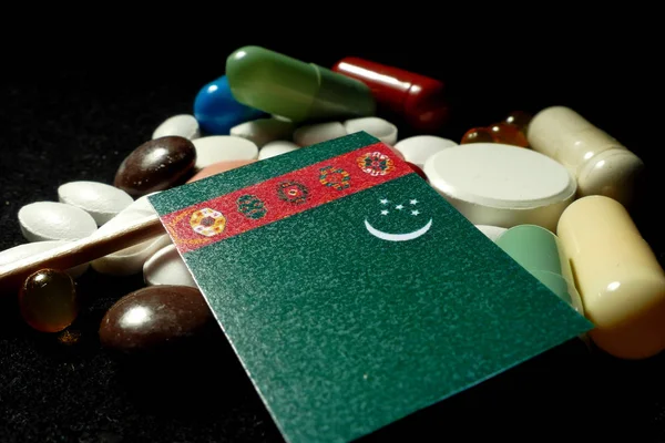 Bandeira do Turquemenistão com muitos comprimidos médicos isolados em preto — Fotografia de Stock