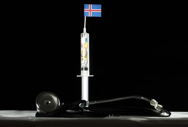Estetoscópio e seringa cheios de drogas injetando a bandeira islandesa em um fundo preto — Fotografia de Stock