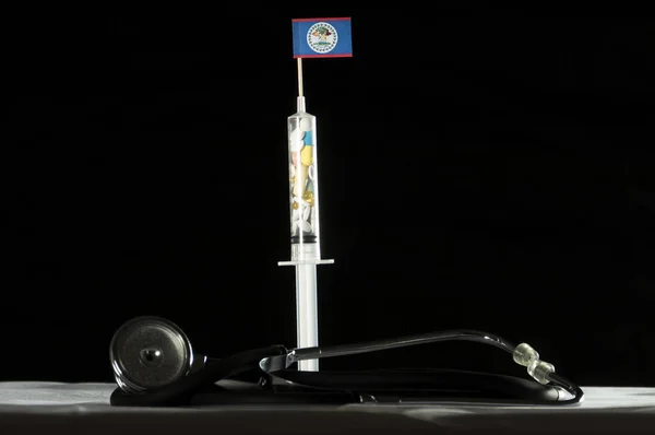 Belize bayrağı siyah bir arka plan üzerinde enjekte ederek uyuşturucu stetoskop ve şırınga dolu — Stok fotoğraf