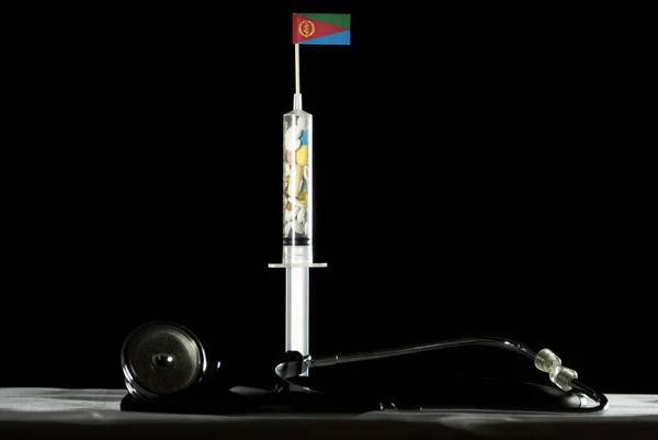 Stetoskop a stříkačka naplněná léků nitrožilně Eritrejská vlajka na černém pozadí — Stock fotografie