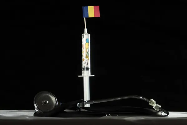 Estetoscópio e seringa cheios de drogas injetando a bandeira do Chade em um fundo preto — Fotografia de Stock