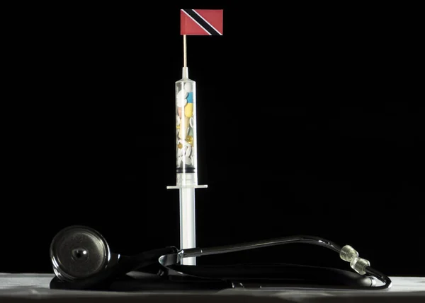Trinidad ve Tobago bayrağı siyah bir arka plan üzerinde enjekte ederek uyuşturucu stetoskop ve şırınga dolu — Stok fotoğraf