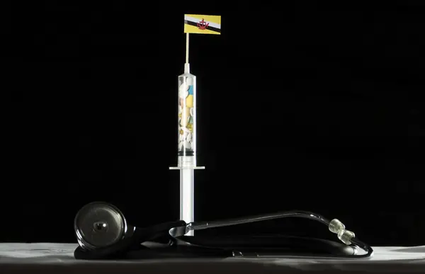 Estetoscópio e seringa cheios de drogas injetando a bandeira Brunei em um fundo preto — Fotografia de Stock