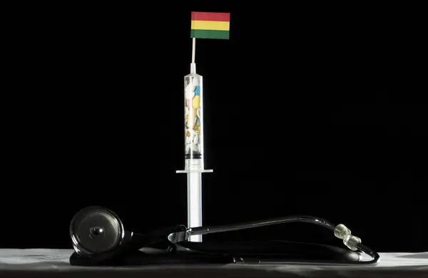 听诊器、 注射器装满药物注射在黑色背景上的玻利维亚标志 — 图库照片