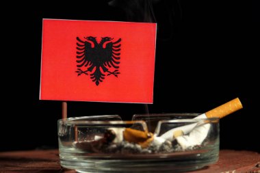 Sigara siyah arka plan üzerine izole kül tablası içinde yanma ile Arnavutluk bayrağı