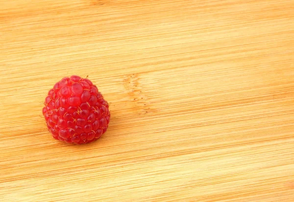 Een raspberry geïsoleerd op houten plank close-up — Stockfoto